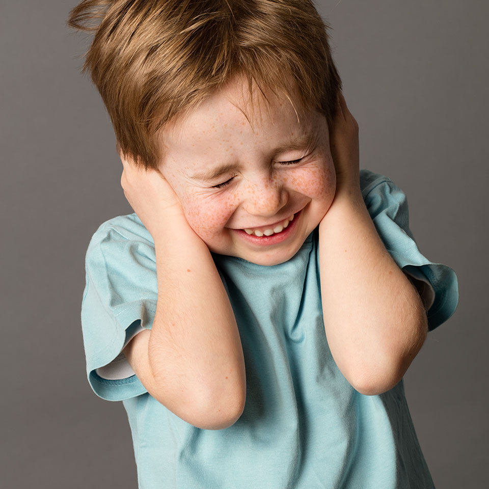 Junge hält sich die Hände an den Kopf